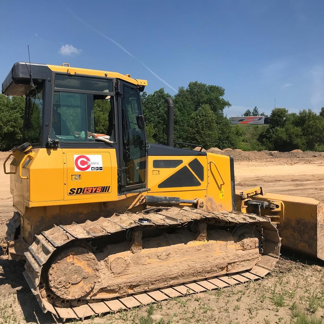 Actual rented yellow bulldozer with a Clusco sticker, original user-provided field photo